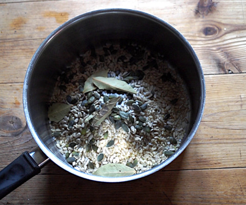 Brown rice, sunflower seeds, and pumpkin seeds, with bay leaves for flavour, ready for boiling