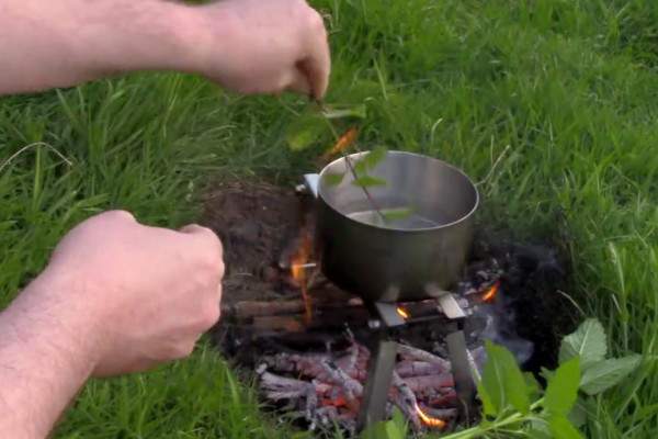 Making nettle tea outdoors on the stick-fire grate.